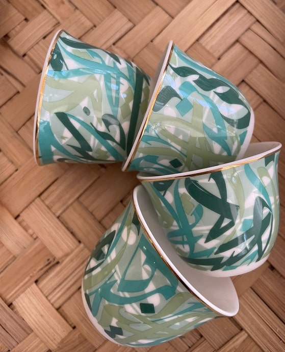 alt="porcelain arabic coffee cups with arabic calligraphy in green"